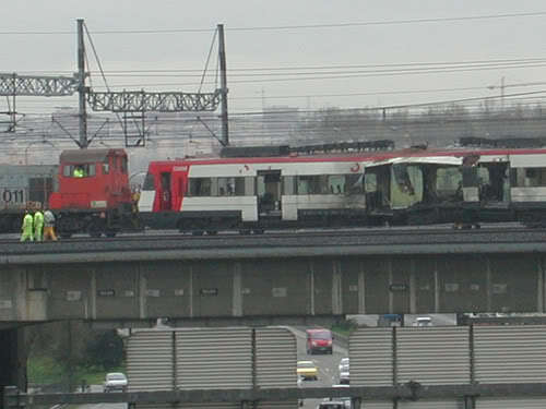 Personal a pie acompaña al tractor de maniobras acoplado al coche 6 en su paso sobre la M-30