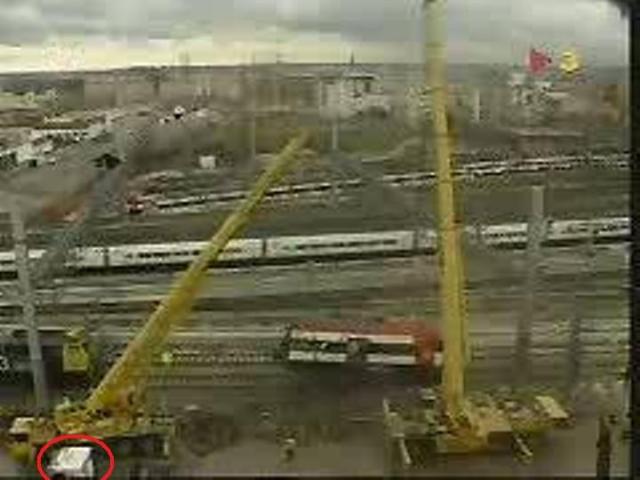 La mitad delantera del coche 4 suspendida de las grúas. A la izquierda, la locomotora que colabora en el movimiento del tren