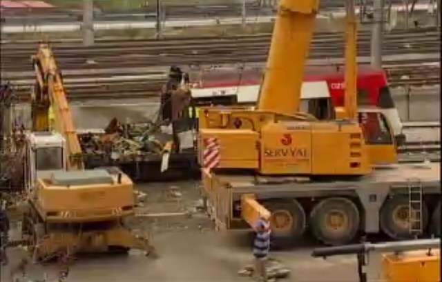 Grúa preparada para el izado, mientras la cizalla sigue trabajando. El mástil de iluminación aparece plegado