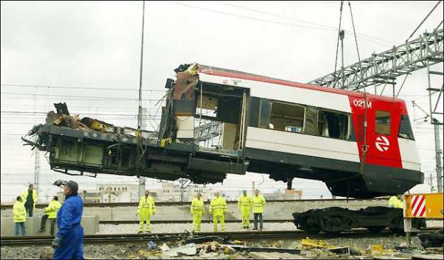 La mitad delantera del coche 1 suspendida de la grúa. El bogie delantero permanece en la vía