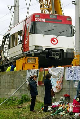 La mitad delantera del coche 1 depositándose en la plataforma del camión
