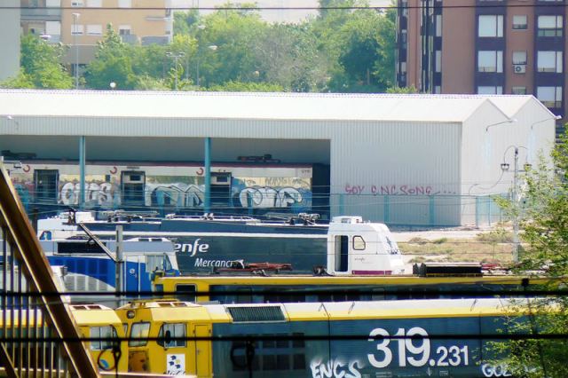 7 de mayo de 2009. Material ferroviario estacionado en el taller TCR de Villaverde. Al fondo una nave con su fondo cerrado alberga un coche de cercanías