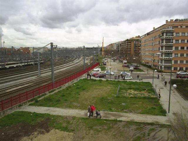 Vista general de la zona de salida de los camiones. Al fondo, las grúas trabajan en el cargue de esos camiones, los cuales vendrían después para girar a su izquierda por la calle Cocheras, que es la que forma la esquina de los edificios del primer plano
