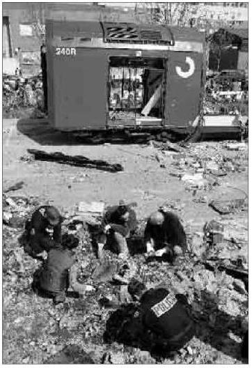 Foto de El Mundo del 16 de marzo de 2004. Policías buscando, el 15 de marzo de 2004, entre los restos del coche 5 de El Pozo