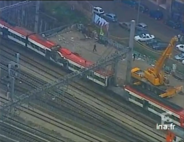 Una grúa junto al coche 6, en posición de trabajo, con los apoyos sacados y en el suelo. El coche 6 está extraordinariamente limpio