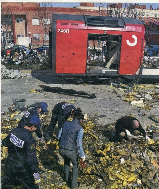 Foto de El Mundo del 21 de mayo de 2007. Policías buscando, el 15 de marzo de 2004, entre los restos del coche 5 de El Pozo. Al fondo, el colegio Madrid Sur, en el que se instaló un colegio electoral el día 14