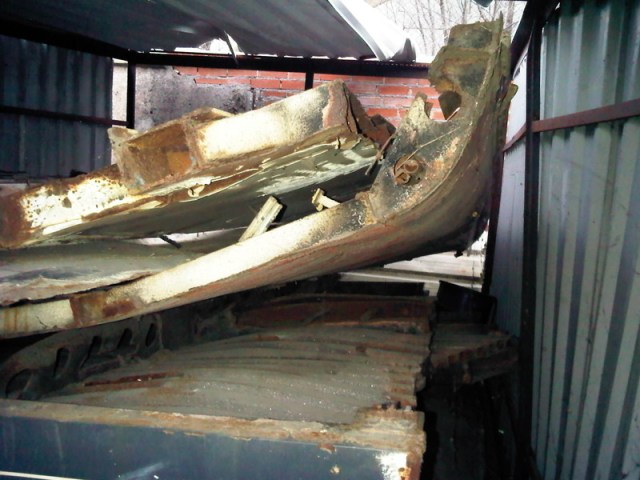 Chapas deformadas y oxidadas amontonadas en el interior del cobertizo