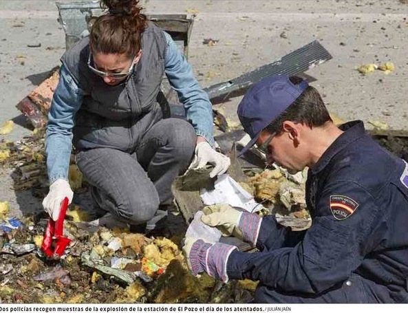 Foto de El Mundo del 9 de marzo de 2011 (pie de foto erróneo, no está tomada “el día de los atentados”, sino cuatro días después)). Policías buscando, el 15 de marzo de 2004, entre los restos del coche 5 de El Pozo